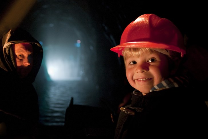 A child on their family days out UK, sailing along the underground river